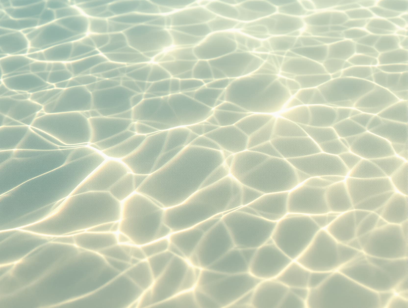 Abstract macro texture of soft morning light rippling across shallow pale mint-green water over a smooth sandy bed, gent